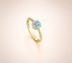 Anello Magic con zircone acquamarina centrale e contorno di micro-zirconi bianchi